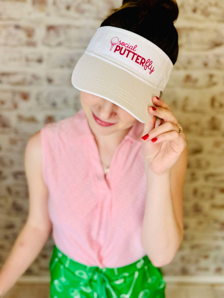 Visor for golfing.  Social PUTTERFLY with a golf ball on a T in reddish pink lettering.