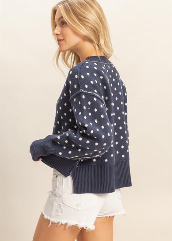 Dottie style crewneck blue sweater with snowflake pattern and raised white seams on shoulders and sleeves
