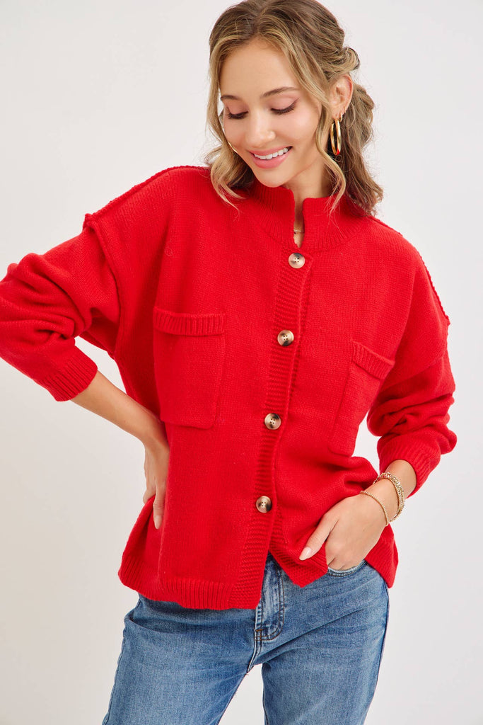 Bold red knit cardigan with a mock collar and patch pockets.  The fit is relaxed, and the trim is ribbed with stated buttons for closure